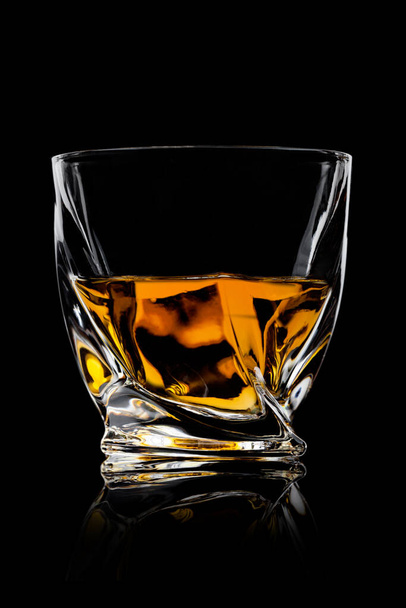 Scotch whiskey in crystal modern luxury glass on black background with reflection. - Foto, Imagem