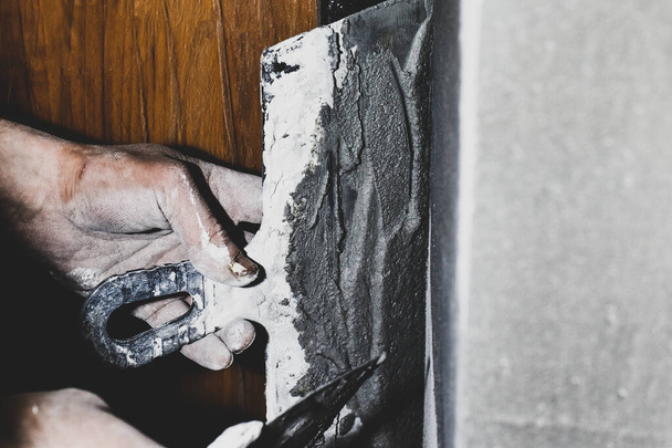 Egy férfi szintetizálja a falakat egy spatulával - Fotó, kép