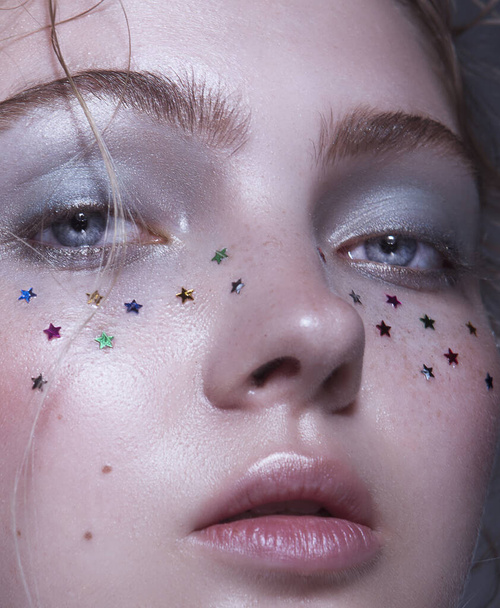 close up of woman face with glitter in star shape  - Foto, afbeelding
