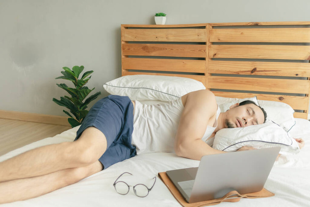 Sleepy leniwy człowiek pracuje z domu, ale spać przed laptopem. - Zdjęcie, obraz