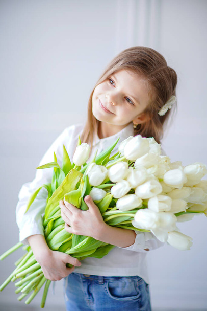 Portrait of beautiful pretty girl with white flowers tulips. Indoor photo - Fotografie, Obrázek