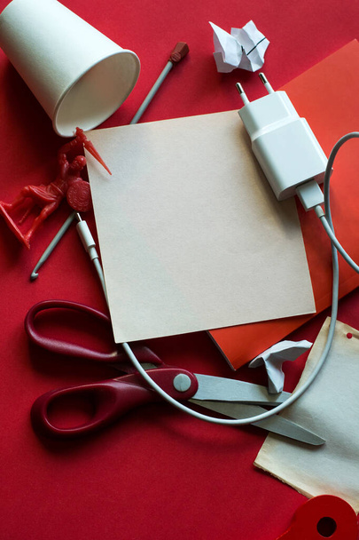 photo for mock up red background composition of red items of paper charger and scissors - Photo, Image