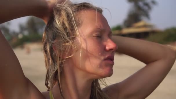 Retrato de uma jovem mulher loira bonita em um maiô na praia
 - Filmagem, Vídeo