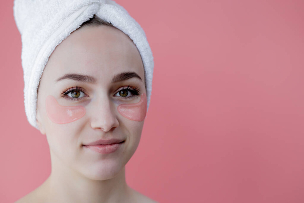Portrait of Beauty Woman with Eye Patches on pink background. Woman Beauty Face with Mask under Eyes. Skin care, cosmetic product concept with copy space. - Foto, imagen