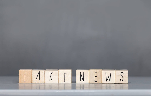 Cupola di legno con le parole Fake News su sfondo grigio, concetto di fake news social media
 - Foto, immagini