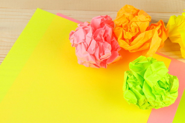 kleurrijke verfrommeld papier ballen op houten achtergrond - Foto, afbeelding