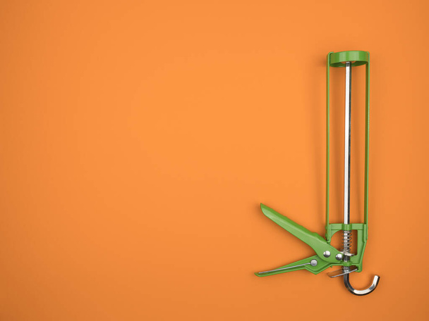 Sealant gun on a orange  background. The view from the top. Green painting tool. - Photo, Image