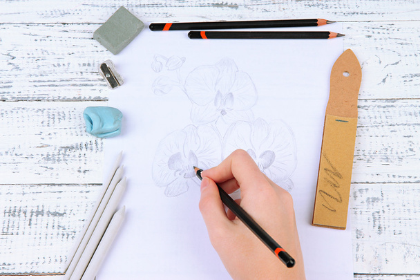 Hand draws a sketch with professional art materials, on wooden table - Photo, image