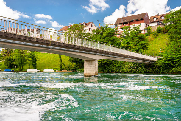 Puente de hormigón sobre el río en un hermoso color turquesa, bosque visible a lo largo del río
. - Foto, imagen