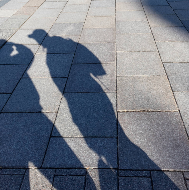 Human shadow on paving slabs. - Foto, Bild