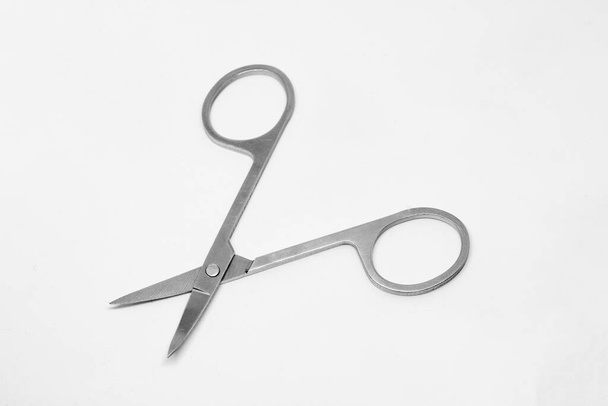 Szare metalowe nożyczki do manicure w stanie rozłożonym na białym tle - Zdjęcie, obraz