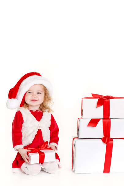 Child holding present wearing santa hat isolated on white - Foto, imagen