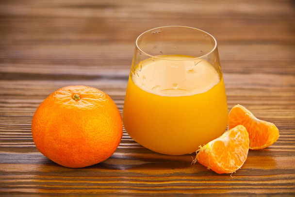 Delizioso succo di mandarino spremuto fresco in un bicchiere trasparente
 - Foto, immagini