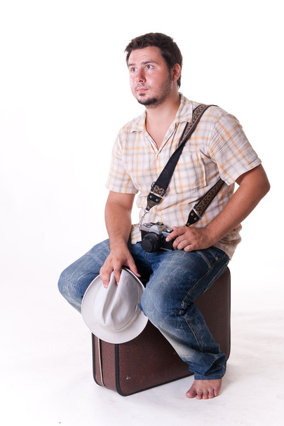 Young man with old-fashion 35mm camera, hat and suitcase, on white - Photo, Image