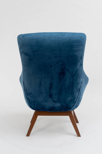 niebieskie welurowe krzesło z drewnianymi nogami na białym tle - Zdjęcie, obraz