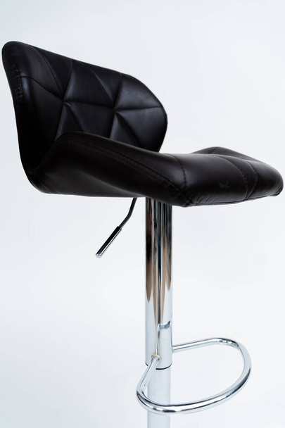 verchromter Barhocker mit schwarz gepolsterter Sitzfläche mit Hintergrund - Foto, Bild