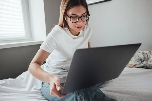 Young woman uses laptop. - Фото, зображення