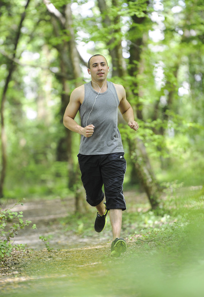 Young man running in the woods - Fotó, kép