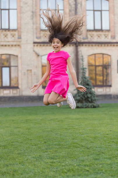 Salon making hair more vital and energetic. Little child jump summer outdoor. Active girl with long brunette hair. Hair salon. Beauty salon. Kids barber. At hairdressers. Salon haircare - 写真・画像