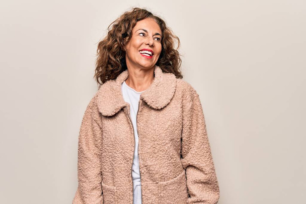Middle age beautiful woman wearing casual jacket standing over isolated white background looking to side, relax profile pose with natural face and confident smile. - 写真・画像