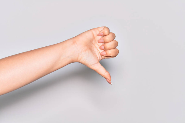 Mão de jovem caucasiana fazendo polegares para baixo gesto de rejeição, desaprovação desgosto e sinal negativo - Foto, Imagem