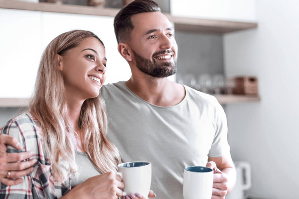 young couple drinking coffee standing in the kitchen - 写真・画像