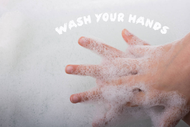 Hand washing and soap foam on a foamy background - 写真・画像