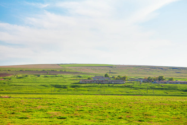 lente landschap met boerderij op groene heuvel  - Foto, afbeelding