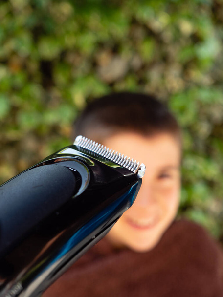 VATER schneidet seinem Sohn zu Hause das Haar, WÄHREN KONFINEMENT - Foto, Bild
