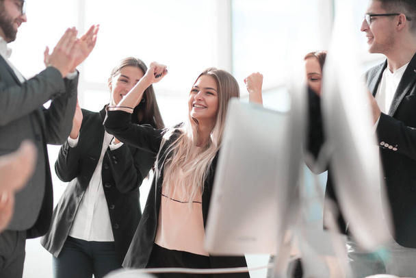 happy group of employees applauds standing in the office - Foto, imagen