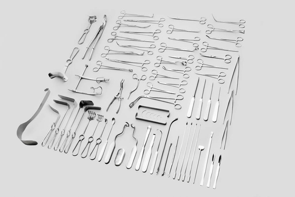 Medical instruments used for surgical operations, laid out on a gray background - Фото, изображение