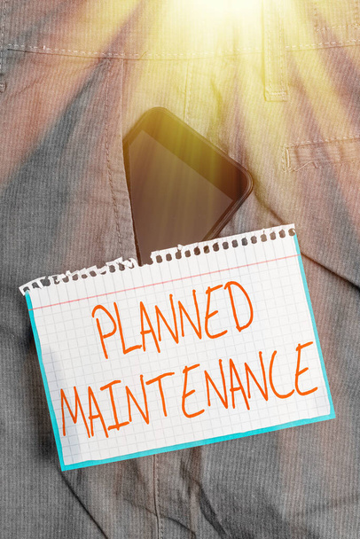 Writing note showing Planned Maintenance. Business photo showcasing Check ups to be done Scheduled on a Regular Basis Smartphone device inside trousers front pocket note paper. - Photo, Image