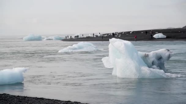 γραφικό εναέρια πλάνα από μικρά παγόβουνα στην παραλία της Γροιλανδίας την ηλιόλουστη μέρα - Πλάνα, βίντεο