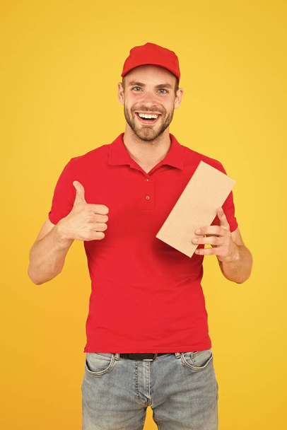 Super fast courier agent. Service delivery. Salesman career. Courier and delivery. Postman delivery worker. Man red cap yellow background. Delivering purchase. Delivering happiness and needs - Foto, imagen