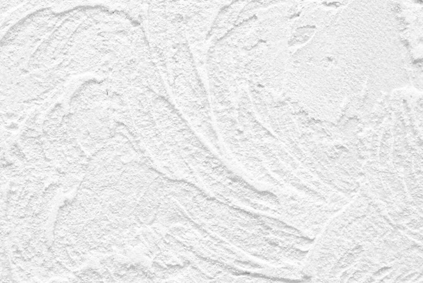 Το φόντο του υπερυψωμένου λευκού τοίχου ολοκληρώνεται με διακοσμητικό σοβά. Αφηρημένες ραβδώσεις σαν κύματα σε τσιμεντένιο τοίχο. Ανακαίνιση μελέτης παλαιών κατοικιών και εμπορικών ακινήτων. Πολυτελής υφή. - Φωτογραφία, εικόνα