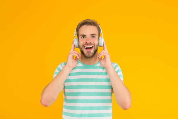 Thats what I call music. Happy guy listen to music yellow background. Handsome man enjoy music playing in headphones. Modern life. New technology. Fun and entertainment. Lost in music - Valokuva, kuva