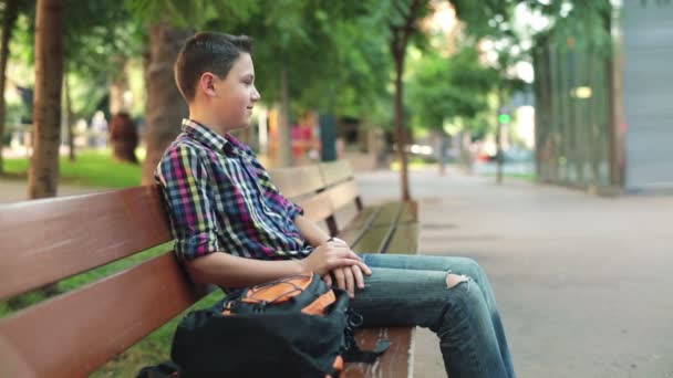Teenager relaxing on bench - Filmagem, Vídeo