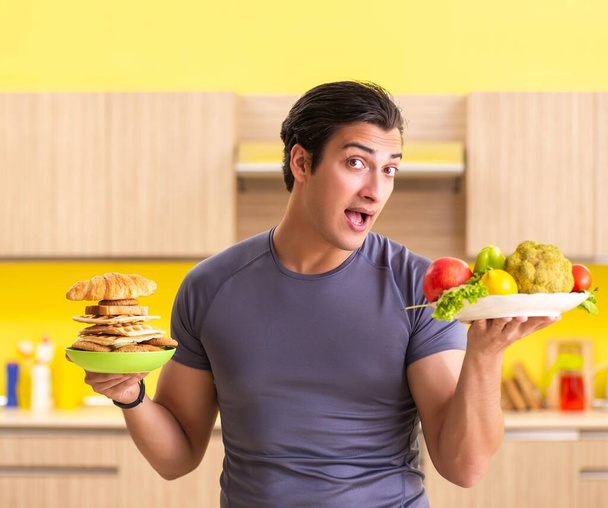 Homem tendo escolha difícil entre alimentos saudáveis e não saudáveis
 - Foto, Imagem