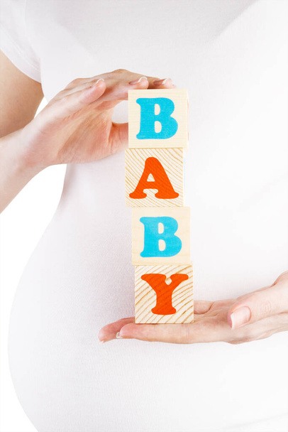 Pregnant woman holding wooden blocks - baby - Zdjęcie, obraz