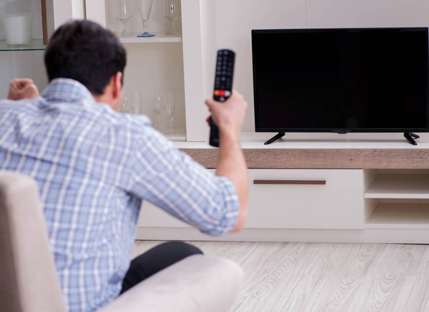 Jeune homme regardant la télévision à la maison - Photo, image