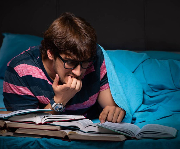 Νεαρός μαθητής που προετοιμάζεται για εξετάσεις τη νύχτα στο σπίτι - Φωτογραφία, εικόνα
