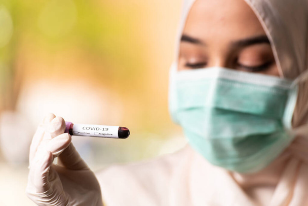 Medical Doctor Nurse Muslim Woman Wearing Protective Mask and Gloves - Holding Virus Blood Test - Valokuva, kuva