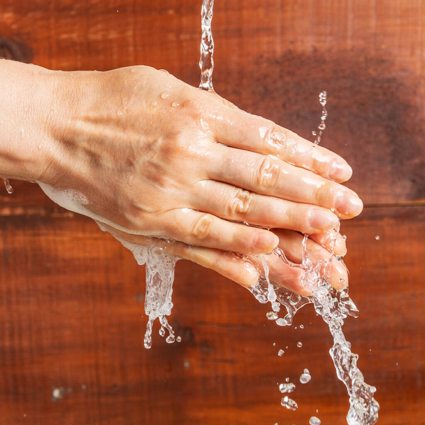 Una donna si lava le mani sotto un getto d'acqua, Igiene durante una pandemia
. - Foto, immagini