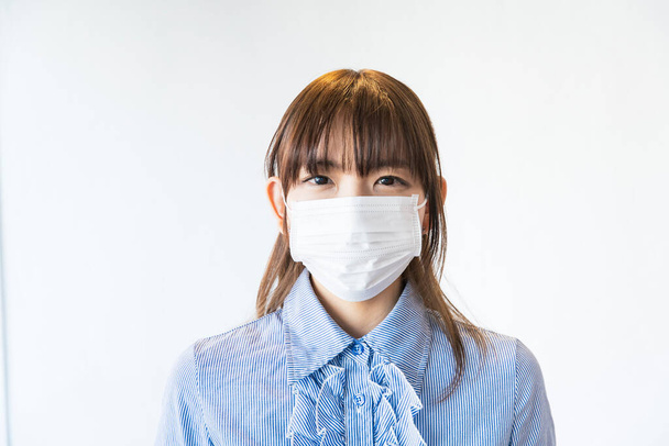 Mulher asiática usando máscara do nariz ao queixo para evitar a infecção por gotículas
 - Foto, Imagem