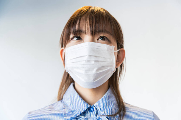 Donna asiatica che indossa una maschera dal naso al mento per prevenire l'infezione da goccioline
 - Foto, immagini