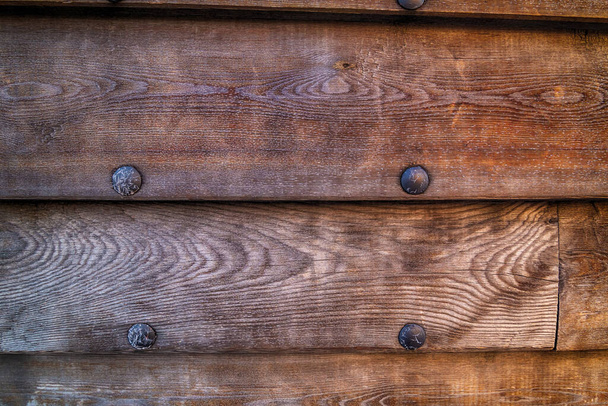 lado de un viejo barco de madera una fila de tablas horizontales erosionadas con remaches de hierro
 - Foto, imagen