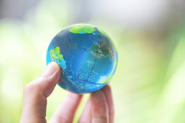 Мир в руке с природой фон / рука держит земной шар окружающей среды Зеленая планета сохранить концепцию дня Земли
  - Фото, изображение
