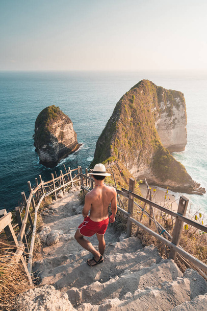 A man traveller walking down to Kelingking beach in Nusa Penida island near Bali island in Indonesia, Asia - Fotografie, Obrázek