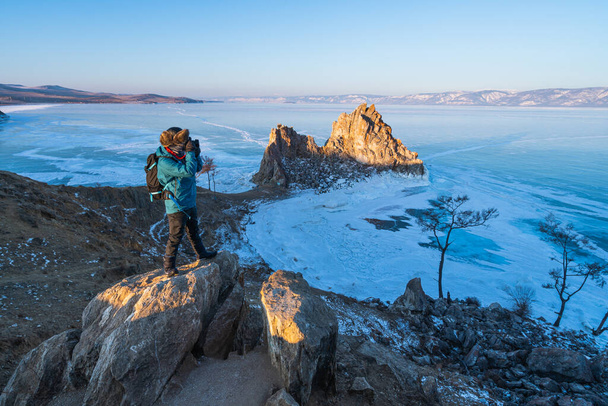 Fotograf z plecakiem robienie zdjęcia Baikal zamarzniętego jeziora rano, Olkhon wyspa, Syberia, Rosja, Azja - Zdjęcie, obraz