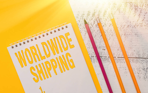Handwriting text Worldwide Shipping. Concept meaning Sea Freight Delivery of Goods International Shipment Blank spiral notepad colored paper sheet markers retro wooden background. - Photo, Image